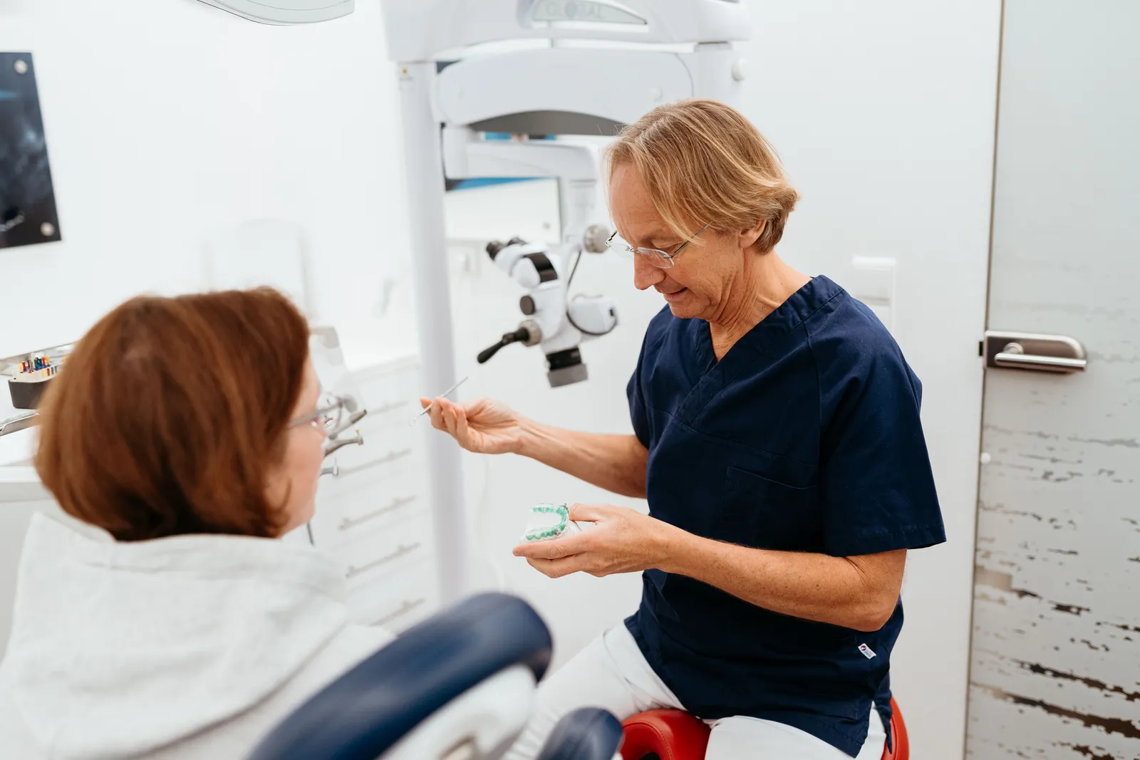 Zahnärztin erklärt einer Patientin die Behandlung